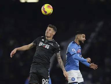Penyerang Empoli, Andrea Pinamonti dan penyerang Napoli, Lorenzo Insigne melompat saat berebut bola dalam laga pekan ke-17 Serie A Liga Italia di Stadion San Paolo pada Senin (13/12) dini hari WIB. Napoli tumbang di markas sendiri saat menjamu Empoli, 0-1. (Alessandro Garofalo/LaPresse via AP)