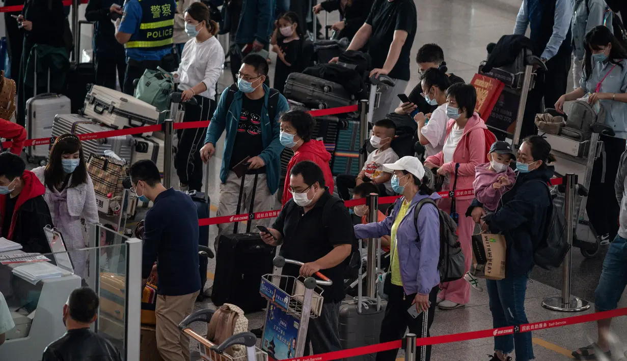 Orang-orang mengantre check-in untuk penerbangan domestik menjelang liburan "Golden Week" di Bandara Internasional Ibu Kota Beijing pada 30 September 2020. Gelombang liburan melanda China yang warganya merayakan libur panjang, yang dikenal dengan Golden Week. (NICOLAS ASFOURI / AFP)