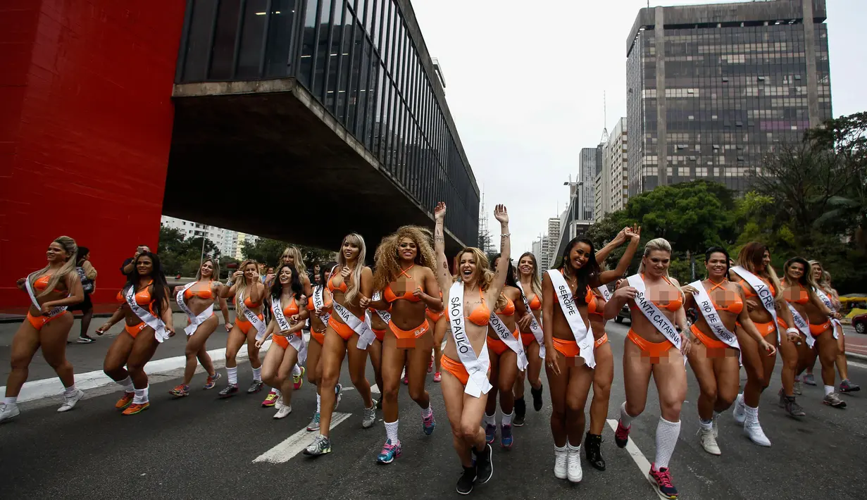 Deretan wanita seksi ketika menyusuri jalanan di Sao Paulo, Senin (8/8). Mengenakan bikini, para wanita tersebut mempromosikan kontes Miss BumBum 2016 yaitu kontes yang menganugerahi wanita dengan pantat terindah seantero Brasil. (Miguel SCHINCARIOL/AFP)