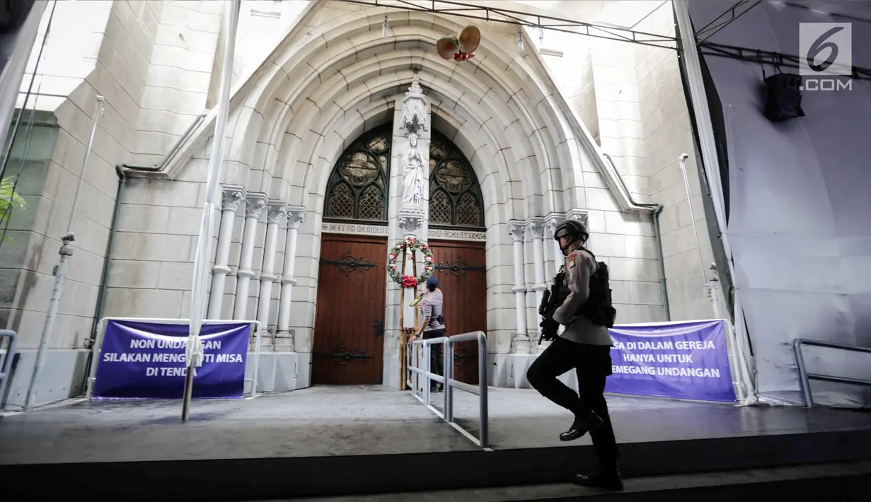 Personel Gegana dan K9 Polda Metro Jaya melakukan penyisiran di gerabng pintu saat sterilisasi Gereja Katedral, Jakarta, Minggu (24/12). (Liputan6.com/Faizal Fanani)