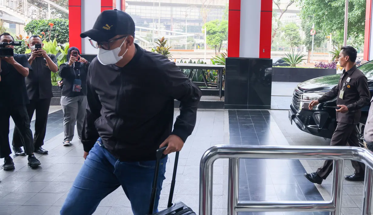 Bupati Klaten Hamenang Wajar Ismoyo tiba di Gedung Merah Putih KPK dengan mengenakan pakaian kasual, topi hitam, kacamata, dan masker putih, Jumat (16/10/2026). Ia langsung memasuki gedung tanpa memberikan keterangan kepada awak media. (officialkpkri)