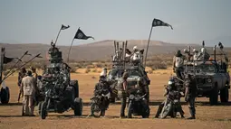 Para peserta berbaris dengan kendaraan ATV mereka selama konvoi mobil dalam Wasteland Weekend di Gurun Mojave, North Edwards, California, AS, Sabtu (28/9/2019). Panitia mengharuskan peserta yang mengikuti Wasteland Weekend berdandan ala karakter dalam film Mad Max. (Agustin Paullier/AFP)