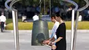 Dua wanita membunyikan lonceng sebagai tanda waktu atau jam bom atom meledak 70 tahun lalu di Hiroshima, Jepang, (6/8/2015). 140.000 penduduk Jepang tewas akibat Bom Atom. (REUTERS/Thomas Peter)