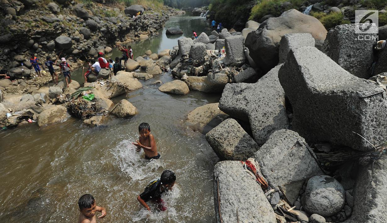 Anak-anak bermain pada kubangan air yang tersisa di kawasan Bendungan Katulampa, Bogor (15/7). Musim kemarau menyebabkan Bendungan Katulampa berada di titik nol berdampak pada sumur-sumur warga di sekitar mengalami kekeringan. (Merdeka.com/Arie Basuki)