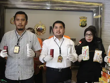 Kasubdit II Ditresnarkoba Polda Metro Jaya AKBP Doni Alexander (kedua kiri) menunjukkan barang bukti  saat rilis 20 ribu narkotika jenis happy five di Direktorat Reserse Narkoba Polda Metro Jaya, Jakarta, Senin (27/8). (Liputan6.com/Herman Zakharia)