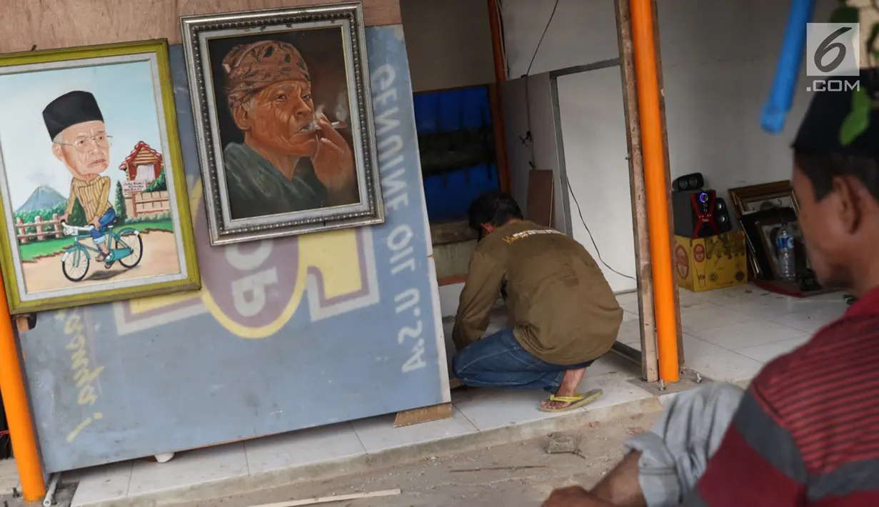 Seniman lukis memasang dinding lapak kios di Sentra Lukisan Pasar Baru, Jakarta, Jumat (16/11). Pemerintah Provinsi DKI Jakarta merevitalisasi 29 kios di Sentra Lukisan Pasar Baru. (Liputan6.com/Immanuel Antonius)