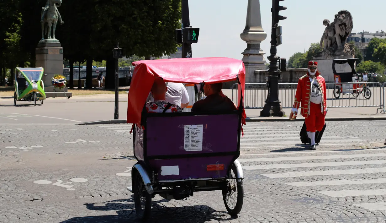 Wisatawan berkeliling kota Paris menggunakan transportasi becak, Prancis, (7/7). Desain becak di Paris ini memiliki posisi penarik becak dibagian depan berbeda dengan becak yang ada di Indonesia. (AFP Photo/Jacques Demarthon)