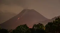 Foto yang diambil pada awal 18 April 2021 ini menunjukkan lava mengalir turun dari puncak Gunung Merapi, gunung berapi teraktif di Indonesia, digambarkan dari Kaliurang dekat kota Yogyakarta. (AFP/Agung Supriyanto)
