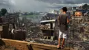 Seorang pria melihat sisa-sisa rumah yang hangus di lingkungan Educandos di Manaus, Brasil (17/12). Kebakaran diduga disebabkan oleh ledakan panci presto yang menghanguskan ratusan rumah warga. (AP Photo/Edmar Barros)