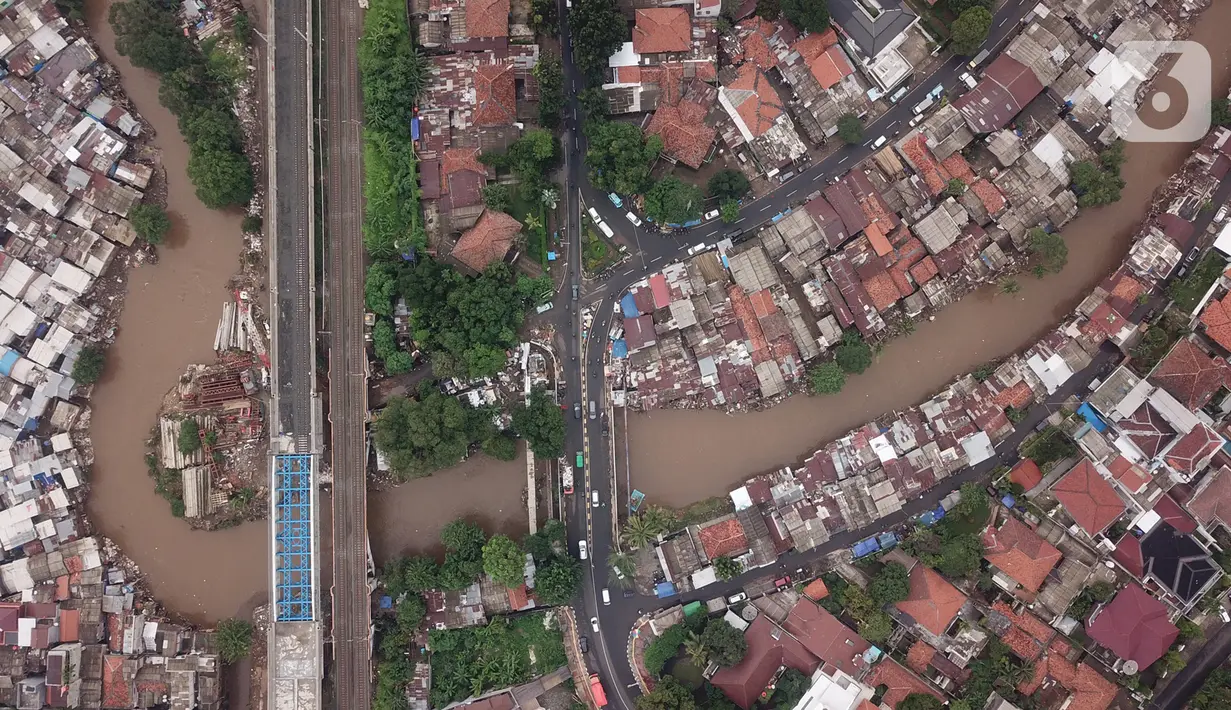 Foto udara suasana Sungai Ciliwung yang diapit pemukiman padat penduduk di kawasan Manggarai, Jakarta, Selasa (7/1/2020). Pemprov DKI Jakarta akan membebaskan 118 bidang lahan untuk proyek normalisasi Sungai Ciliwung pada tahun 2020 yang tersebar di empat kelurahan. (Liputan6.com/Immanuel Antonius)