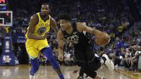 Forward Milwaukee Bucks Giannis Antetokounmpo (kanan) melewati bintang Golden State Warriors Kevin Durant pada laga NBA di Oracle Arena, Kamis (29/3/2018) atau Jumat (30/3/2018) WIB. (AP Photo/Marcio Jose Sanchez)