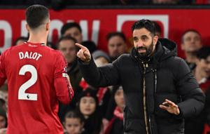 Pelatih kepala Manchester United asal Portugal, Ruben Amorim (kanan), berbicara dengan bek Manchester United asal Portugal bernomor punggung 02, Diogo Dalot (kiri), selama pertandingan Liga Inggris antara Manchester United dan Bournemouth di Old Trafford, Manchester, barat laut Inggris, Sabtu (27-12-2025) dini hari WIB. (PETER POWELL/AFP)