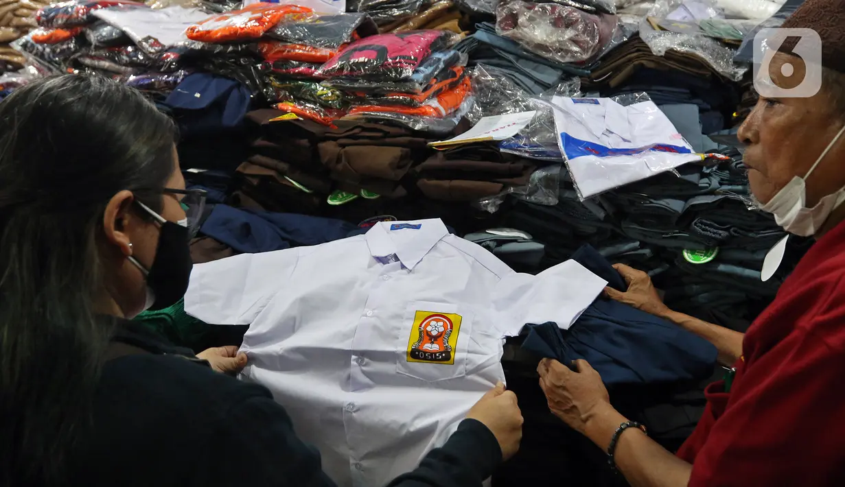 Pedaan 
Pedagang melayani pembeli seragam sekolah di Pasar Mester, Jakarta , Minggu (29/8/2021). Menurut pedagang, penjualan seragam sekolah kembali meningkat hingga 30 persen jelang masuk sekolah tatap muka yang dilaksanakan kembali pada 30 Agustus 2021. (Liputan6.com/Herman Zakharia)