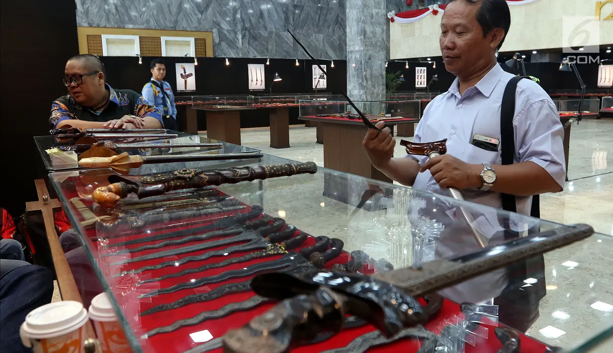 Pengunjung melihat koleksi keris saat Pameran Keris Madura di Gedung Nusantara, Kompleks Parlemen Senayan, Jakarta, Kamis (21/3/2019). Pameran itu untuk memperkenalan kekayaan budaya keris Madura di lingkungan parlemen DPR. (Liputan6.com/Johan Tallo)