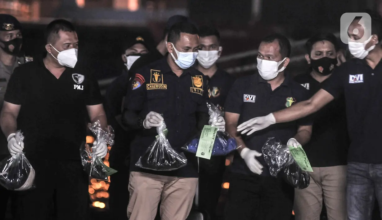 Tim DVI Polri mengidentifikasi pakaian korban kecelakaan Sriwijaya Air SJ 182 yang baru ditemukan tim SAR gabungan di Dermaga JICT 2, Tanjung Priok, Jakarta, Minggu (10/1/2021). Pencarian Sriwijaya Air SJ 182 dilakukan dengan mengerahkan kapal-kapal. (merdeka.com/Iqbal S. Nugroho)