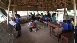 Gambar pada 20 Mei 2019, siswa India mengikuti kegiatan belajar mengajar di sekolah Forum Akshar di desa Pamohi, Guwahati. Sekolah ini mengambil pendekatan baru untuk mengatasi momok sampah plastik dengan menjadikannya sebagai syarat pengganti biaya sekolah. (Biju BORO/AFP)