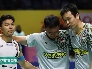 Ganda putra Indonesia, Hendra Setiawan, berusaha menangkan Mohammad Ahsan yang bersedih setelah tersingkir dari Indonesia Masters 2025 di Istora Senayan Jakarta, Kamis (23/1/2025). (Bola.com/Abdul Aziz)