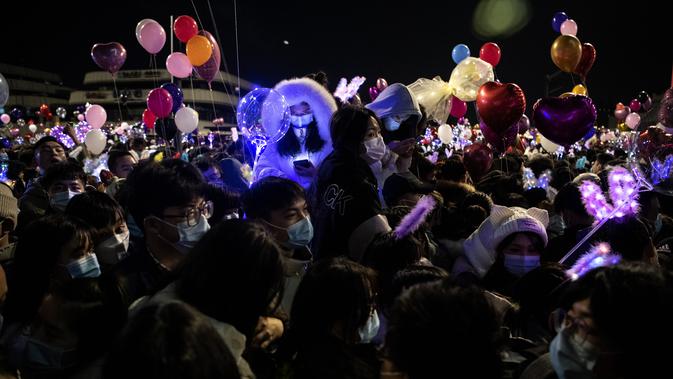 Orang-orang menghadiri hitung mundur di Wuhan, provinsi Hubei tengah China, pada 31 Desember 2020, meskipun ada pembatasan Covid-19 dan kembang api Tahun Baru dibatalkan. (AFP/Noel Celis)