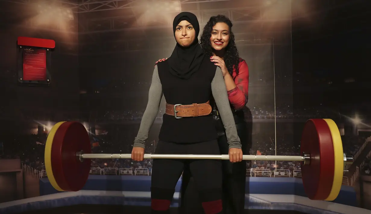 Amna Al Haddad, juara angkat besi UEA berpose dengan patung lilinnya pada pembukaan museum Madame Tussauds di Dubai, Uni Emirat Arab, Rabu (13/10/2021). Atraksi lilin terkenal di dunia ini menampilkan koleksi patung lilin dari lebih 60 tokoh terkenal dunia. (AP/Kamran Jebreili)