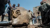 Warga melihat dekat pecahan patung yang ditemukan oleh tim arkeolog Jerman-Mesir di distrik Mattarya, Kairo, Kamis (9/3). Diduga pecahan patung yang digali di sekitar Kuil Ramses II tersebut berasal dari dinasti XIX (1295-1185 SM)