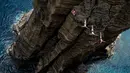 David Colturi, Andy Jones dan Kyle Mitrione dari AS, melakukan lompatan setinggi 21 meter dari tebing Islet Franca do Campo pada kompetisi Red Bull Cliff Diving World Series di Sao Miguel, 7 Juli 2017. (Romina Amato/Red Bull Content Pool via AP Images)