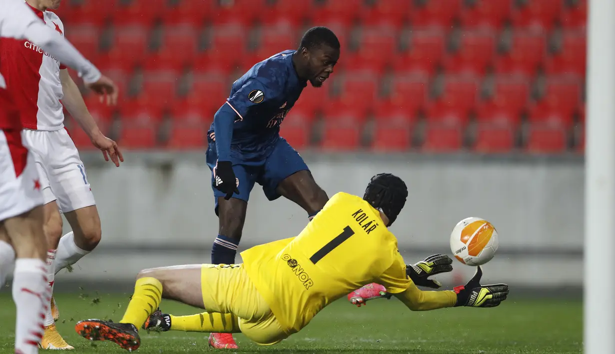 Gelandang Arsenal, Nicolas Pepe (tengah) melepaskan tendangan yang berbuah gol pertama timnya ke gawang Slavia Praha dalam laga leg kedua perempatfinal Liga Europa 2020/2021 di Sinobo Stadium, Praha, Kamis (15/4/2021). Arsenal menang 4-0 atas Slavia Praha. (AP/Petr David Josek)