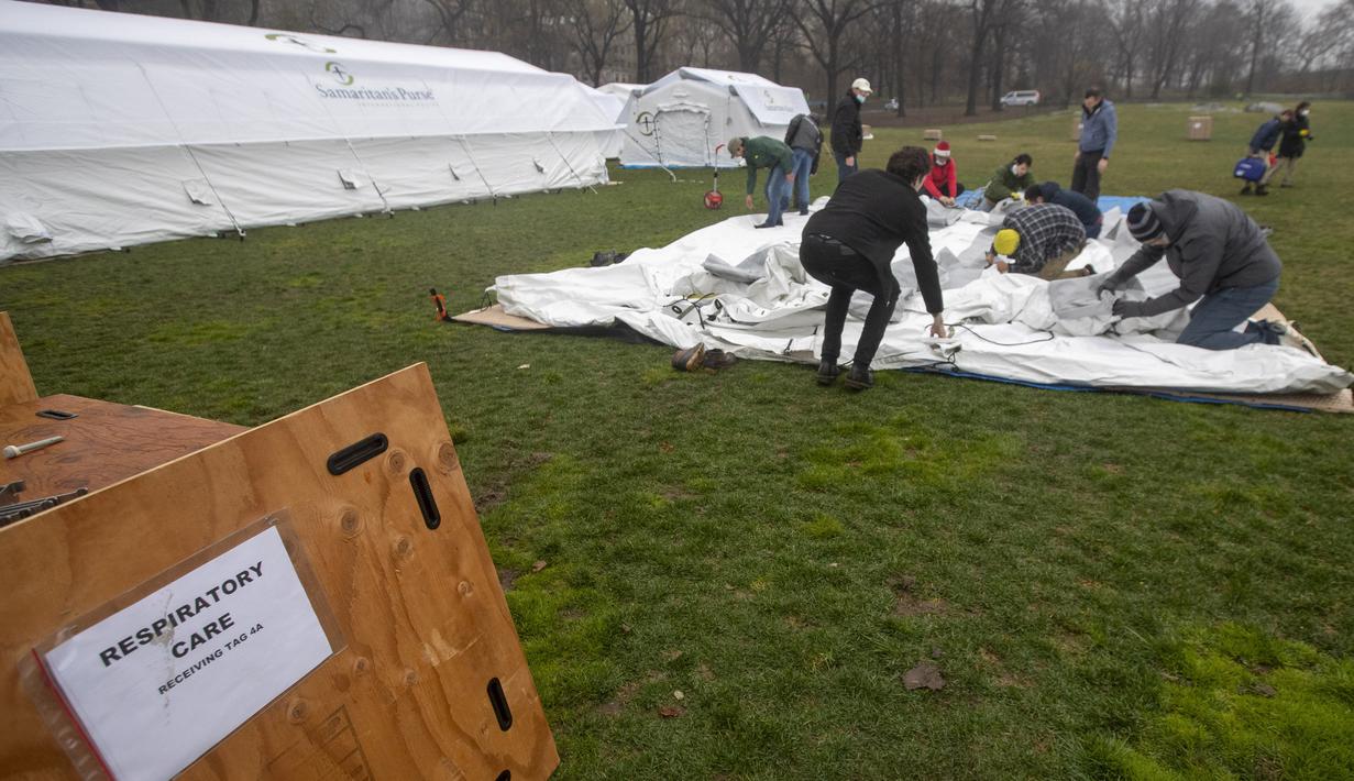 Pekerja Samaritan's Purse membangun rumah sakit lapangan darurat virus corona COVID-19 di Central Park, New York, Amerika Serikat, Minggu (29/3/2020). Rumah sakit lapangan darurat yang dibangun di seberang Rumah Sakit Mount Sinai ini dilengkapi dengan unit pernapasan. (AP Photo/Mary Altaffer)