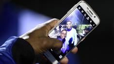 Fans menunjukan foto selfie bersama penyerang MU dan juga timnas Prancis, Anthony Martial usai menonton latihan skuat Les Blues jelang laga persahabatan melawan Jerman di Yvelines, Prancis, Selasa (10/11/2015). (AFP Photo/Franck Fife)
