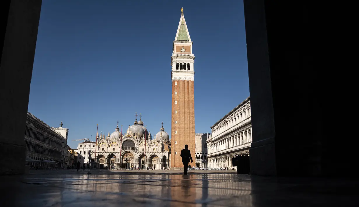Seorang pria melintasi Piazza San Marco, menuju ke Basilika Santo Markus, di Venesia pada 20 Mei 2021. Turis kembali berdatangan menikmati keindahan Venesia, yang sering dijuluki kota paling romantis di dunia, setelah Italia menghapus kewajiban karantina bagi pendatang. (Marco Bertorello/AFP)