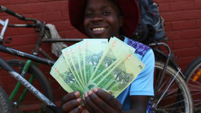 Seorang pria berpose dengan uang kertas baru yang dikeluarkan Reserve Bank of Zimbabwe di Harare, 12 November 2019. Selama hampir satu dekade terakhir, masyarakat Zimbabwe menggunakan sejumlah mata uang negara lain bertransaksi pasca krisis ekonomi yang terjadi di Afrika. (AP/Tsvangirayi Mukwazhi)