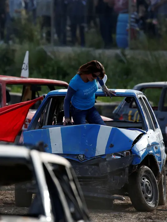 Pengemudi keluar dari kendaraannya yang mengalami kerusakan saat kompetisi saling menghancurkan mobil 'Demolition Derby'  di Ta 'Qali, Malta pada 10 Maret 2019. Kompetisi tersebut dimainkan oleh pengemudi wanita. (REUTERS/Darrin Zammit Lupi)