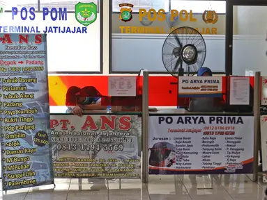 Calon penumpang melintas di depan agen tiket bus di Terminal Jatijajar, Depok, Jawa Barat, Senin (6/7/2020). Terminal tipe A tersebut kembali mengoperasikan layanan bus Antar Kota Antar Provinsi (AKAP) dengan menerapkan protokol kesehatan. (Liputan6.com/Herman Zakharia)