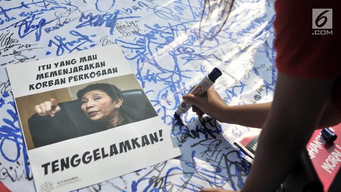 Massa yang tergabung dalam Jaringan Muda Setara menandatangani bentuk dukungan untuk WA korban pemerkosaan saat menggelar aksi di kawasan Bundaran HI, Jakarta, Minggu (5/8). (Merdeka.com/Iqbal S. Nugroho)