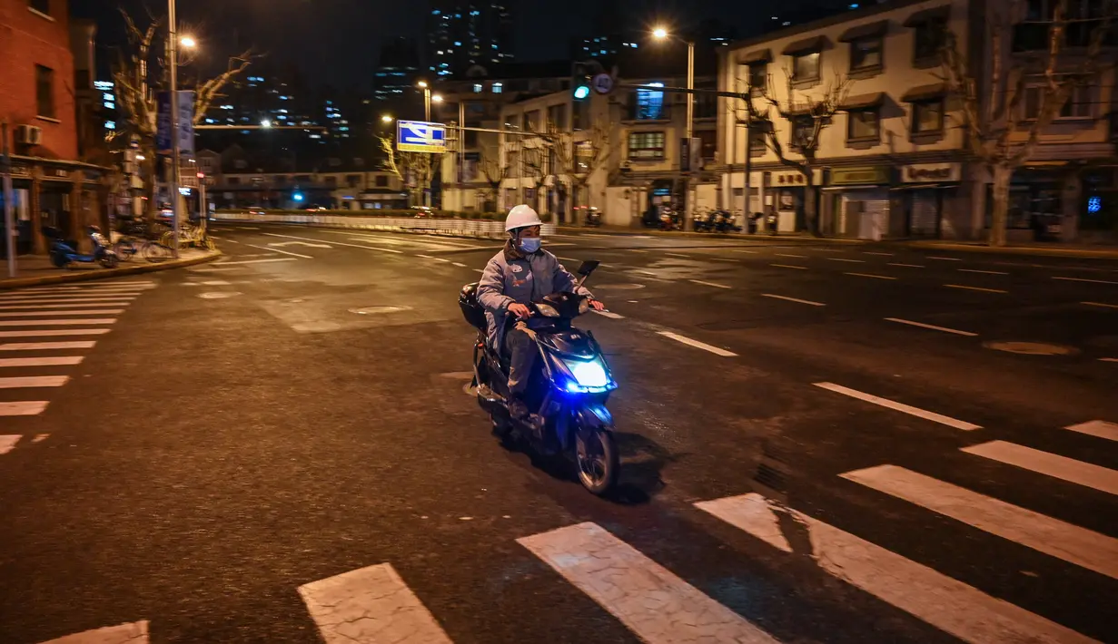 Seorang pria mengendarai skuter di jalan sebelum dimulainya lockdown tahap kedua sebagai tindakan pencegahan terhadap virus corona COVID-19 di Shanghai, China, 31 Maret 2022. (Hector RETAMAL/AFP)