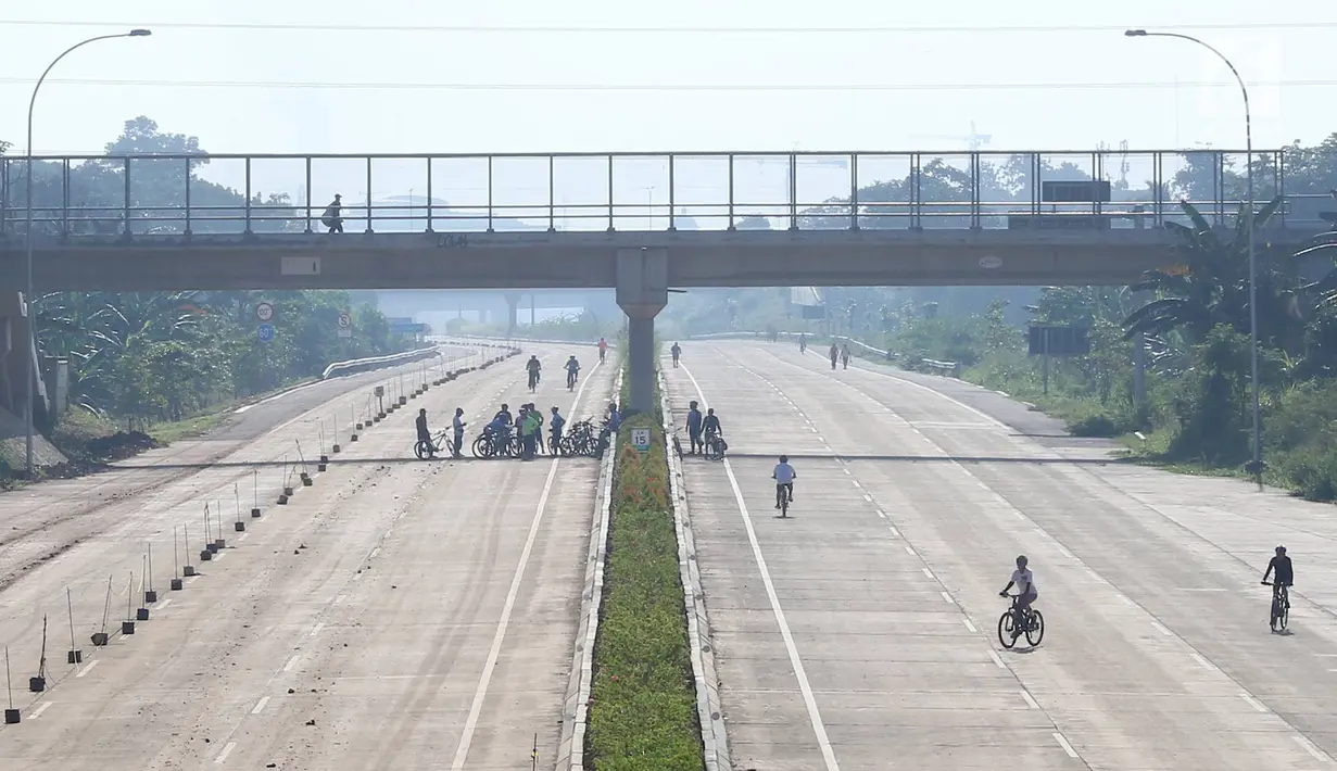 Warga berolahraga di proyek Jalan Tol Cijago Seksi II, kawasan Kukusan, Depok, Minggu (6/1). Proyek yang hampir rampung itu dimanfaatkan untuk berolahraga dengan menyusuri jalur yang belum dilalui kendaraan bermotor. (Liputan6.com/Immanuel Antonius)