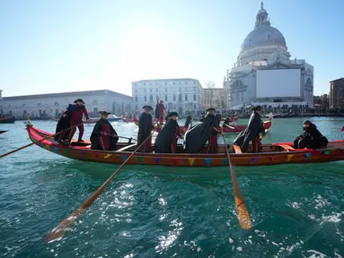 Perahu berlayar saat parade dayung tradisional, bagian dari Karnaval Venesia, di Venesia, Italia, Minggu (28/1/2024). (AP Photo/Luca Bruno)