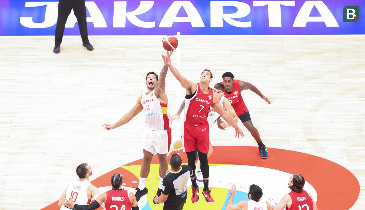 Pebakset Kanada, Dwight Powell (tengah kanan) berebut dengan pebasket Spanyol, Willy Hernangomez saat melakukan tip off pada laga Grup L Piala Dunia FIBA 2023 di Indonesia Arena, Senayan, Jakarta, Minggu (03/09/2023). Kanada lolos ke babak perempat final setelah menang dengan skor 88-85. (Bola.com/Bagasakara Lazuardi)