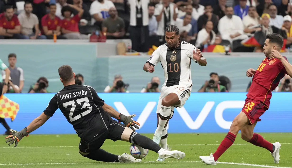 <p>Pemain Timnas Jerman, Serge Gnabry (tengah) berusaha menjebol gawang Spanyol yang dijaga Unai Simon&nbsp;dalam pertandingan Grup E Piala Dunia 2022 yang berlangsung di Al Bayt Stadium, Qatar, Senin (28/11/2022). (AP Photo/Matthias Schrader)</p>