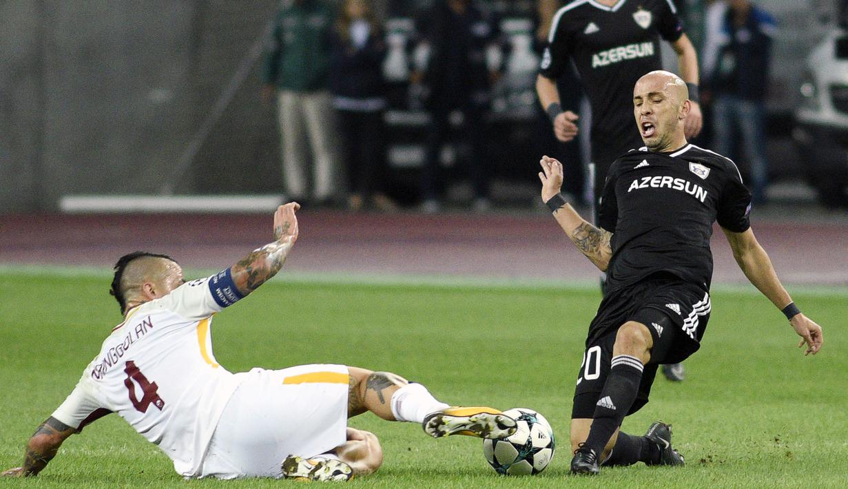 Aksi pemain AS Roma, Radja Nianggolan (kiri) berusaha mghalau bola sepakan pemain Qarabag FK, Richard pada laga grup C Liga Champions di Baki Olimpiya Stadionu, Baku, (27/9/2017). AS Roma menang 2-1. (AFP/Tpfik Babayev)