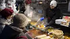 Seorang pekerja melayani pelanggan di pasar Advent Bazilika, salah satu pasar Natal luar ruangan paling terkenal di Eropa di pusat kota Budapest, Hungaria, Sabtu, 9 Desember 2023. (AP Photo/Denes Erdos)
