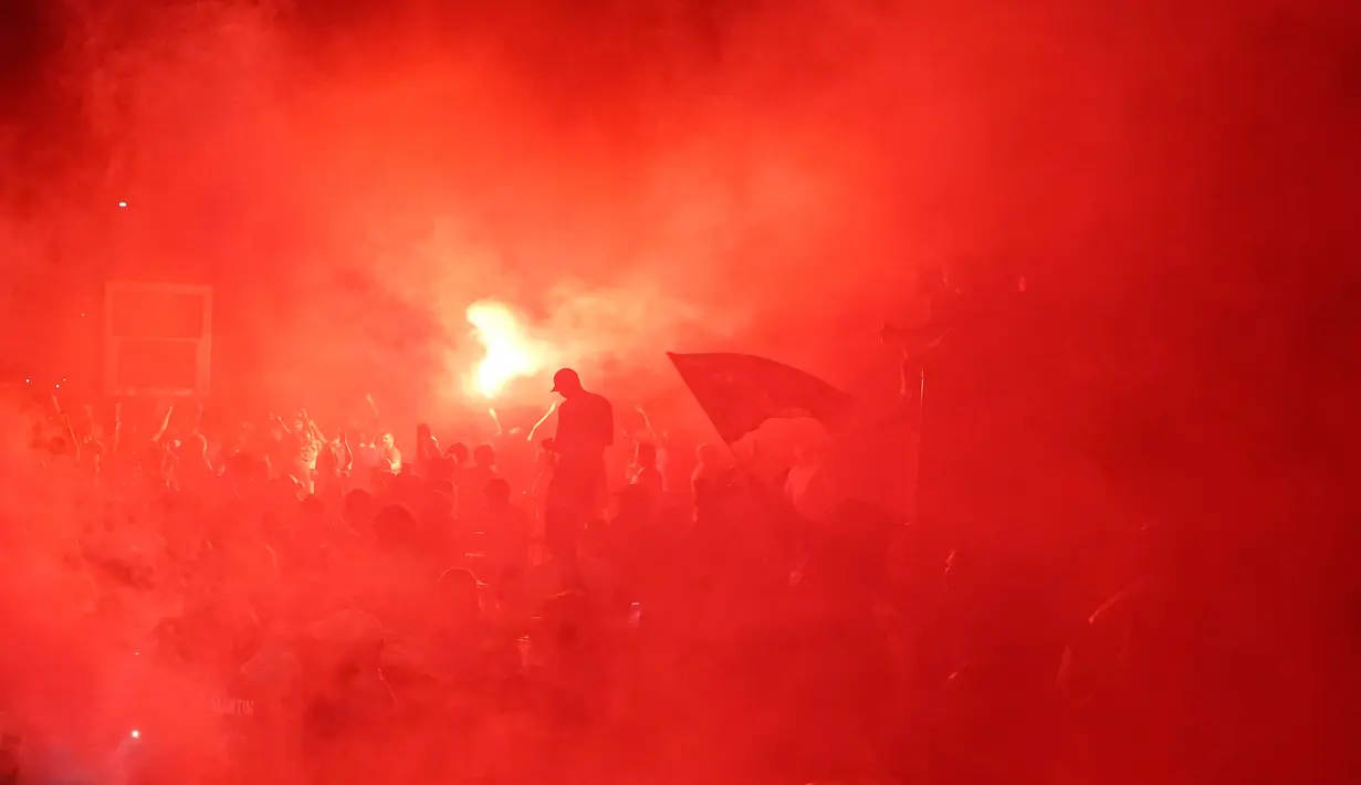 Pendukung Liverpool merayakan gelar juara Liga Premier di luar Stadion Anfield, Kamis (25/6/2020). Trofi juara Liga Primer musim 2019-2020 Trofi juara Liga Primer musim 2019-2020 tersebut dimenangkan Liverpool setelah Manchester City takluk 1-2 dari Chelsea. (AP/Jon Super)