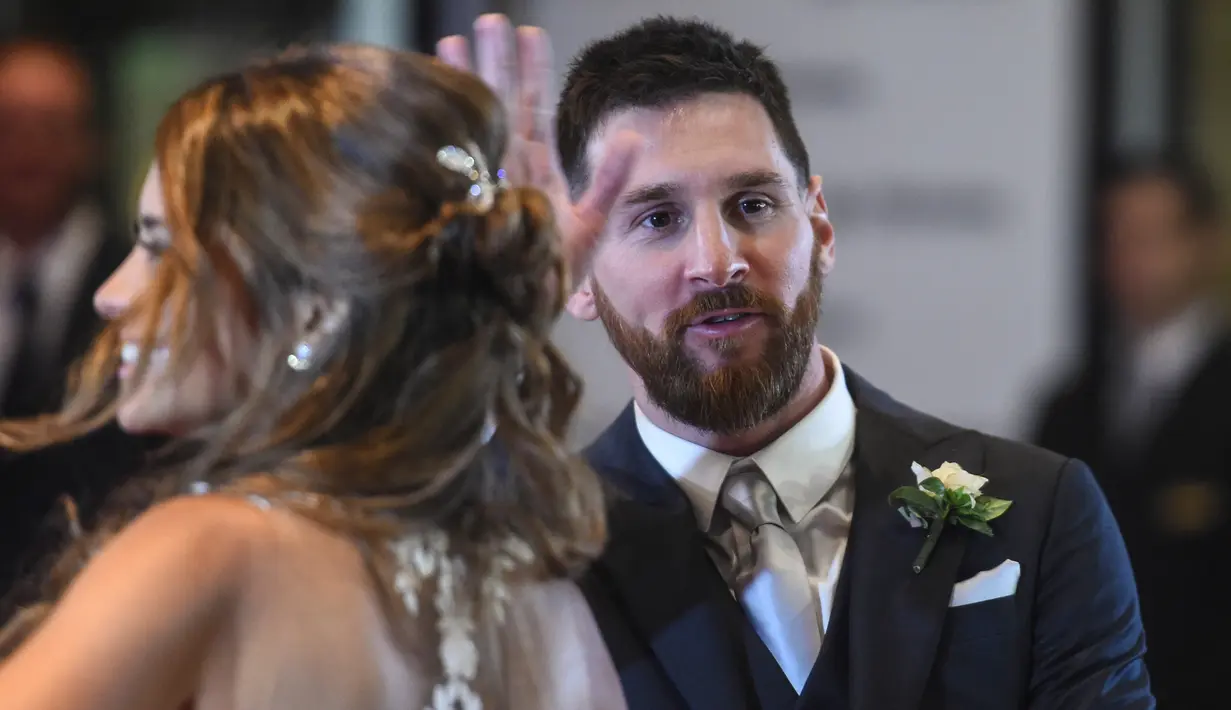 Bintang sepak bola, Lionel Messi  menyapa awak media usai melangsungkan pernikahan di Rosario, provinsi Santa Fe, Argentina (30/6). Acara ini dihadiri banyak pesepakbola dan selebriti termasuk penyanyi pop Shakira. (AFP Photo/Eitan Abramovich)