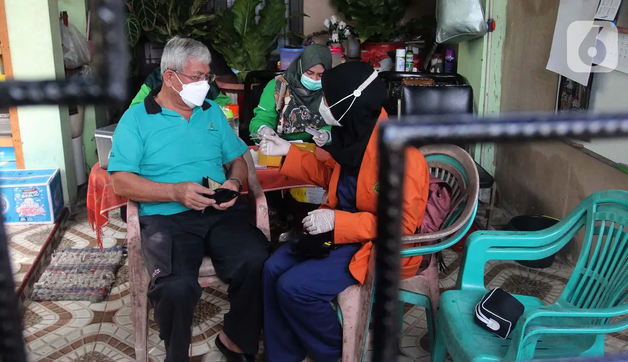 Petugas menyuntikkan vaksin COVID-19 dosis ketiga kepada lansia saat vaksinasi booster COVID-19 dari rumah ke rumah di Poris Plawad, Tangerang, Jumat (21/1/2022). Pelaksanaan vaksinasi dari rumah ke rumah untuk memudahkan para lansia mendapatkan vaksin booster COVID-19. (merdeka.com/Arie Basuki)