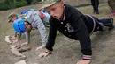 Siswa melakukan push-up saat mengikuti pelatihan di kamp paramiliter di Kiev, Ukraina, (14/7). Konflik yang terjadi di bagian timur Ukraina membuat beberapa orang tua sangat ingin memastikan anak-anak mereka siap jika perang. (AP Photo/Efrem Lukatsky)