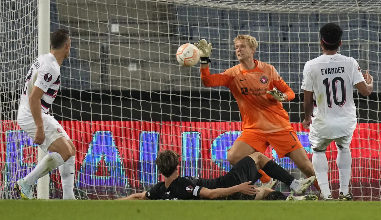Kiper Midtjylland, Jonas Loessl, berusaha menghalau bola saat melawan  pada laga Liga Europa di Graz, Jumat (9/9/2022). (AP/Darko Bandic)