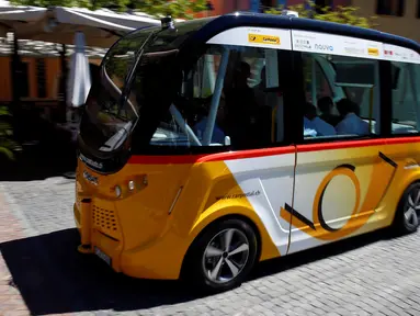 Sebuah angkutan umum tanpa kemudi dan sopir melintasi jalanan Sion, Swiss, Kamis (23/6). Angkutan umum listrik pertama buatan PostAuto Schweiz ini memiliki 11 kursi penumpang dengan kecepatan maksimal 20 km per jam. (REUTERS/Ruben Sprich)