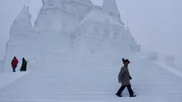 Pengunjung berjalan ditangga sebuah bangunan yang terbuat dari es di kota utara Harbin, provinsi Heilongjiang , Cina, (5/1). Bangunan es yang dibuat menyerupai Istana dengan ukuran yang besar. (REUTERS/Aly Song)