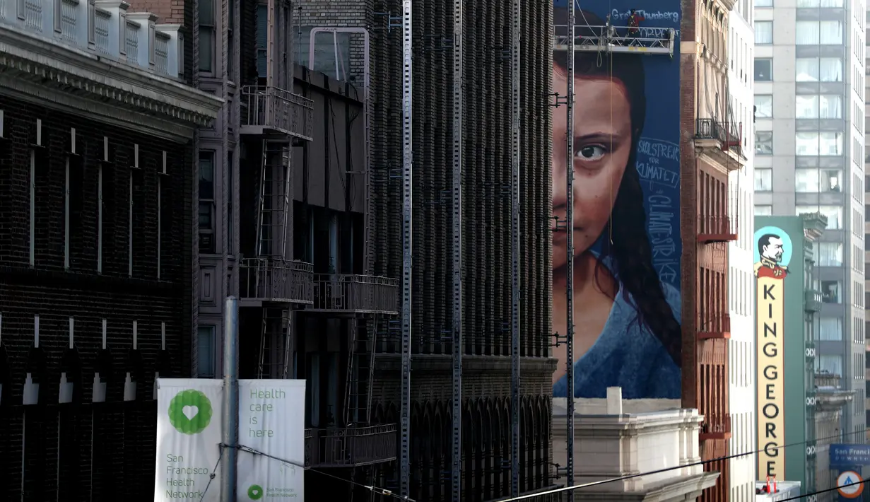 Pemandangan mural dengan gambar aktivis perubahan iklim Greta Thunberg asal Swedia di sebuah gedung di pusat Kota San Francisco, California, 11 November 2019. Mural setinggi 18 meter dan lebar 9 meter itu dibuat seniman jalanan asal Argentina, Andres Petreselli. (Justin Sullivan/Getty Images/AFP)