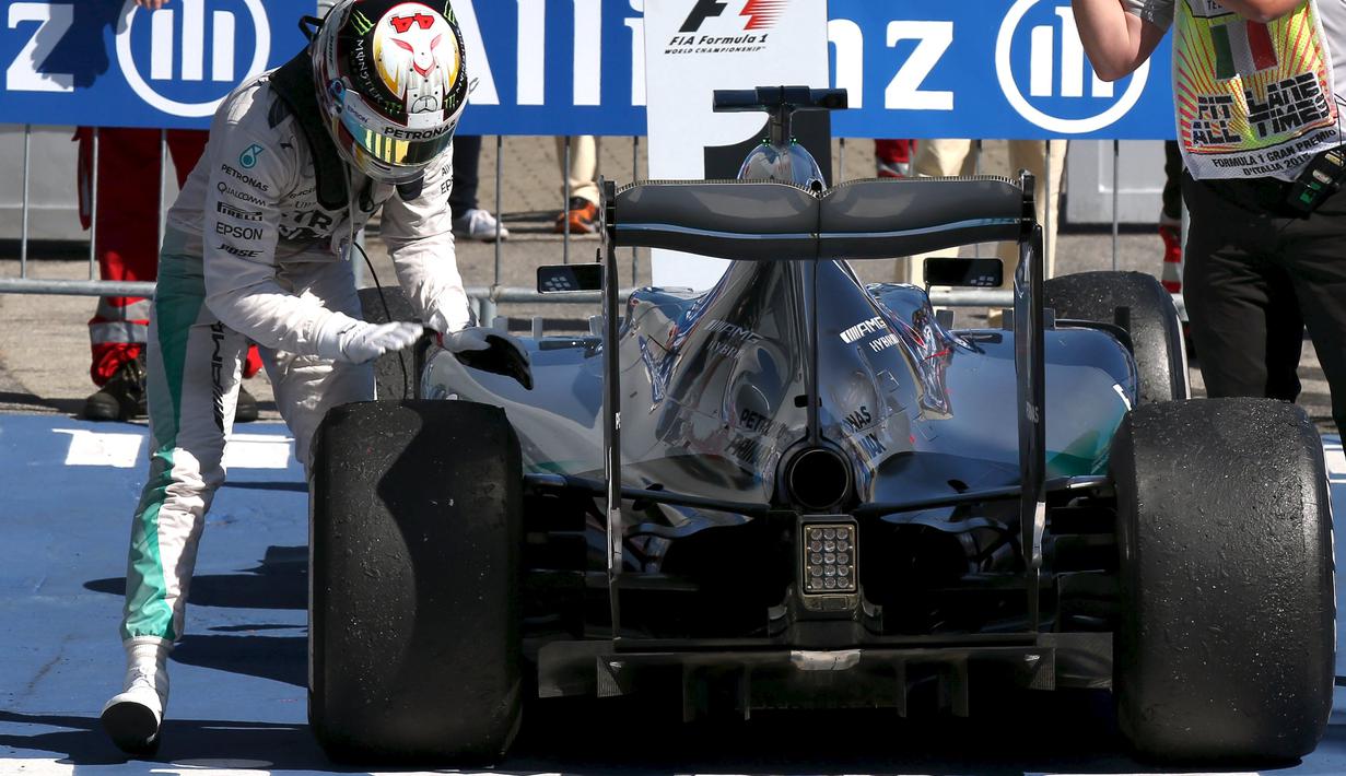 Lewis Hamilton menepuk-nepuk ban mobilnya setelah menjadi juara di Sirkuit Monza. Minggu (6/9/2015). (Action Images for Reuters/Hoch Zwei)