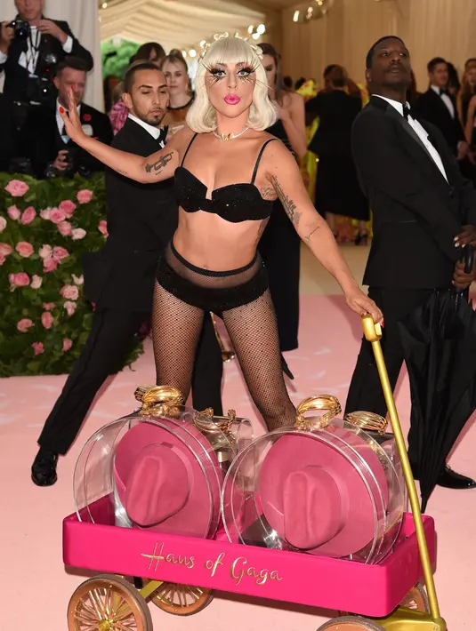 Lady Gaga didampingi para pria yang mengenakan tuksedo saat menghadiri Met Gala 2019 di The Metropolitan Museum of Art, New York, AS, Sanin (6/5/2019). Gaga mengakhiri parade busana dengan hanya mengenakan bra hitam, legging tipis, serta high stiletto heels. (Photo by Evan Agostini/Invision/AP)